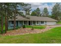Charming single-story home with light blue siding, mature trees, and a well-maintained front yard at 1038 Tenderfoot Dr, Larkspur, CO 80118