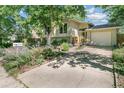 Beautiful home with a well-kept lawn, mature trees, and a concrete driveway leading to the garage at 1080 Ithaca Dr, Boulder, CO 80305