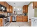 Traditional eat-in kitchen with tile backsplash, granite counters, and stainless steel appliances at 9960 Garland Ln, Broomfield, CO 80021