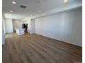 Bright living room with recessed lighting and wood-look floors flowing into a modern kitchen at 6601 N Netherland St, Aurora, CO 80019