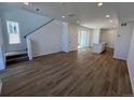 Open-concept living room featuring wood-look floors, staircase, and sliding glass door to the outside at 6601 N Netherland St, Aurora, CO 80019