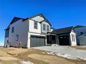 Two-story house with gray and white siding, a dark gray garage door, and a landscaped yard at 907 Congress Pl, Elizabeth, CO 80107