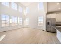 Spacious living room featuring high ceilings, large windows, and light wood floors at 907 Congress Pl, Elizabeth, CO 80107