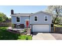 Charming two-story home featuring a red front door, well-manicured lawn, and blooming trees creating curb appeal at 10950 Tennyson Ct, Westminster, CO 80031