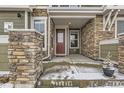 Inviting front porch with stone pillars, a red door, and a charming potted plant at 23545 E Platte Dr # C, Aurora, CO 80016