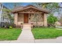 Charming brick home with a well-maintained lawn, inviting front porch, and Craftsman details at 401 S Williams St, Denver, CO 80209