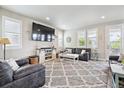 Comfortable living room with ample seating, large TV, plush rug, and natural light from the adjacent windows at 2395 S Troy Ct, Aurora, CO 80014