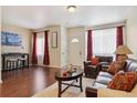 Living room with couches, wood floors, and a coffee table at 4452 S Auckland Ct, Aurora, CO 80015