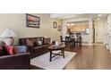 Living room with leather couches, wood floors, and dining area at 4452 S Auckland Ct, Aurora, CO 80015