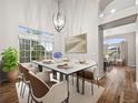 Bright dining room featuring stylish lighting, a large window, and modern furnishings at 5796 E 129Th Pl, Thornton, CO 80602