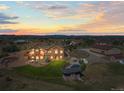 Beautiful home featuring a pool, a large deck, lush landscaping, and a backdrop of stunning sunset skies at 11624 Dunrich Rd, Parker, CO 80138