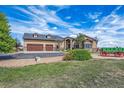 Beautiful home with an attached garage and gorgeous landscaping that features green grass, plants, and a wagon at 11624 Dunrich Rd, Parker, CO 80138