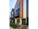 Modern townhome exterior with a combination of metal and siding facade, front porch, and wood railing at 5630 W 11Th Pl, Lakewood, CO 80214