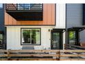Modern townhome exterior with a combination of metal and siding facade, front porch, and wood railing at 5630 W 11Th Pl, Lakewood, CO 80214