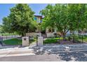 Inviting home with stone accents, mature trees, and a wrought iron fence adding curb appeal at 2600 S Adams St, Denver, CO 80210