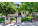 Charming two-story home with stone accents, mature trees, landscaped yard, and wrought iron fence at 2600 S Adams St, Denver, CO 80210