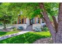 Charming front porch with stone pillars, manicured lawn, and a sidewalk leading to the entryway at 2600 S Adams St, Denver, CO 80210