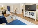 Open floor plan with wood floors, white console, blue sofa, dining area, and bar seating at 2 N Adams St # 108, Denver, CO 80206