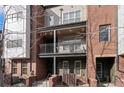 Townhome balcony with iron railings, exterior lighting, and furniture; brick facade at 437 S Reed Ct, Lakewood, CO 80226