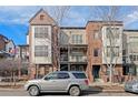 Multi-story townhome with brick and siding, a small balcony, and front-facing garage and minimal landscaping at 437 S Reed Ct, Lakewood, CO 80226