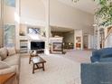 Open-concept living room with fireplace, high ceilings, and comfortable seating at 7858 Oban Ct, Lone Tree, CO 80124