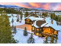 Aerial view of a sprawling home with a heated driveway and a beautiful mountain backdrop amidst a winter wonderland at 219 Glen Eagle Loop, Breckenridge, CO 80424