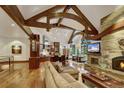 Expansive living room features a stone fireplace, wooden beams, and an open layout connecting to the kitchen at 219 Glen Eagle Loop, Breckenridge, CO 80424
