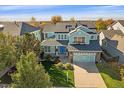 Inviting two-story home featuring manicured lawn and a bright blue front door at 6317 Ruby Hill Dr, Erie, CO 80516