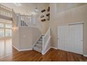 Bright foyer with wood floors, staircase, and decorative luggage wall hangings at 6317 Ruby Hill Dr, Erie, CO 80516