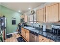 Well-lit kitchen boasts stainless appliances, granite countertops, and natural wood cabinets at 13495 Shiloh Rd, Conifer, CO 80433