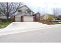 Two-story home with three-car garage, brick accents, and manicured lawn at 18112 E Dorado Ave, Centennial, CO 80015