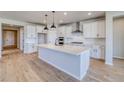 Spacious kitchen featuring a center island with stone countertop and modern light fixtures at 680 Tubman Dr, Elizabeth, CO 80107