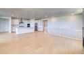 Open-concept living space with hardwood floors, a modern kitchen, and a staircase at 680 Tubman Dr, Elizabeth, CO 80107