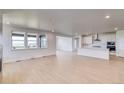 Spacious living area with hardwood floors, large windows, and open layout to the kitchen at 680 Tubman Dr, Elizabeth, CO 80107