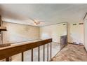 Open living room featuring a fan, a brick fireplace, and stairway to the basement at 1431 S Chambers Cir, Aurora, CO 80012