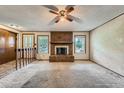 Bright living room featuring a brick fireplace and large windows providing natural light at 1431 S Chambers Cir, Aurora, CO 80012
