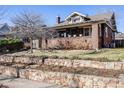 Charming brick home with a cozy front porch and layered landscaping, perfect for gardening enthusiasts at 4135 Hooker St, Denver, CO 80211
