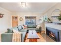 Cozy living room with fireplace, large sofa, hardwood floors, and large window at 4135 Hooker St, Denver, CO 80211