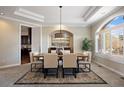 Formal dining area featuring a tray ceiling, modern lighting fixture, and large windows at 145 Capulin Pl, Castle Rock, CO 80108