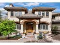 Inviting front entrance with an arched doorway, stone pathway, and manicured landscaping at 145 Capulin Pl, Castle Rock, CO 80108