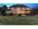 Backyard at twilight, with patio, pergola, outdoor seating, and a large lawn, perfect for relaxation and entertainment at 391 High Ridge Way, Castle Pines, CO 80108