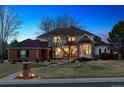 Twilight view of a beautiful brick home with manicured lawn and illuminated walkway, showcasing its curb appeal at 391 High Ridge Way, Castle Pines, CO 80108