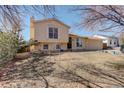 Split level home featuring an attached one car garage, lawn, and windows with white shutters at 1123 S Biscay St, Aurora, CO 80017