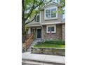 Inviting townhome featuring stone accents, gray siding, and an American flag displayed on the facade at 1203 S Zeno Way # B, Aurora, CO 80017