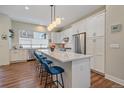 Bright, open kitchen featuring a large island with seating, stainless steel appliances, and modern lighting at 5189 Vivian St, Wheat Ridge, CO 80033