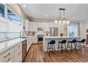 Bright, open kitchen featuring a large island with seating, stainless steel appliances, and modern lighting at 5189 Vivian St, Wheat Ridge, CO 80033