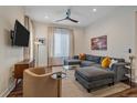 Contemporary living room featuring a large sectional sofa, stylish decor, and a ceiling fan for added comfort at 5189 Vivian St, Wheat Ridge, CO 80033