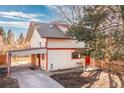 Two story home featuring white siding with red trim, a carport and a well manicured lawn at 11970 W Pleasant Ave, Lakewood, CO 80401