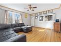 Cozy living room with hardwood floors, a comfortable sofa, and natural light from multiple windows at 11970 W Pleasant Ave, Lakewood, CO 80401