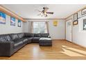 Bright living room with hardwood floors, a comfy gray sectional couch and a ceiling fan at 11970 W Pleasant Ave, Lakewood, CO 80401